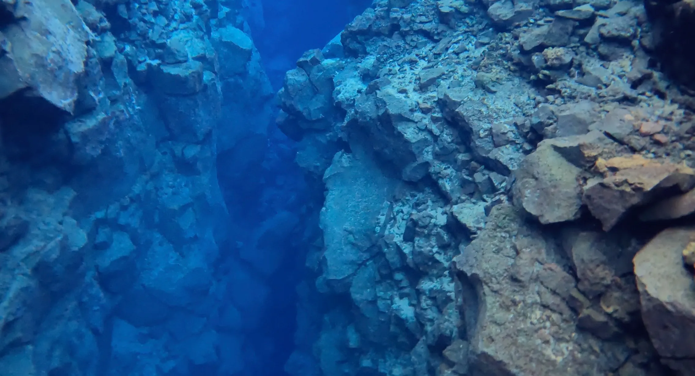 A fissure and a rock formations in the water in Iceland.