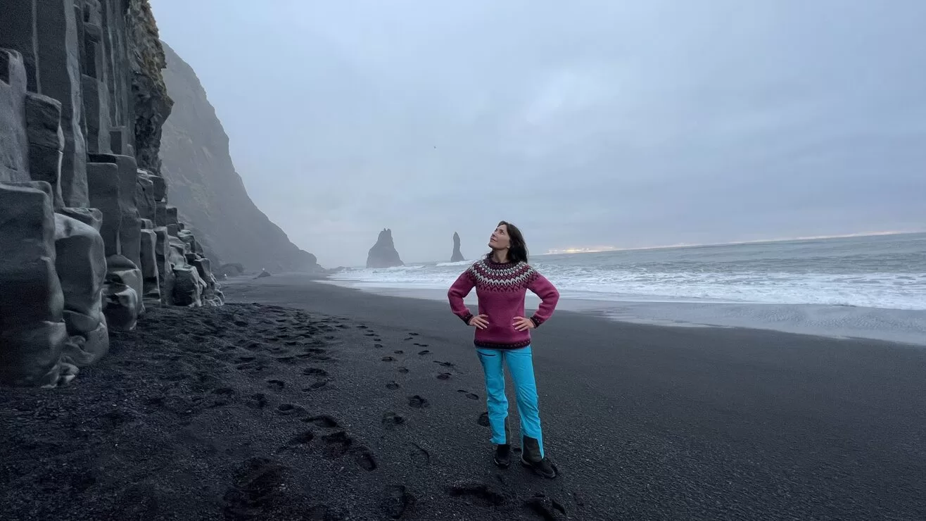 Karen standing on Black Sand Beach with Basalt Columns