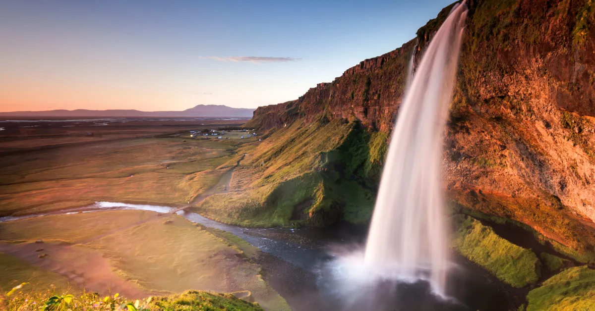 View of Seljalandsfoss waterfall over a rocky cliff.