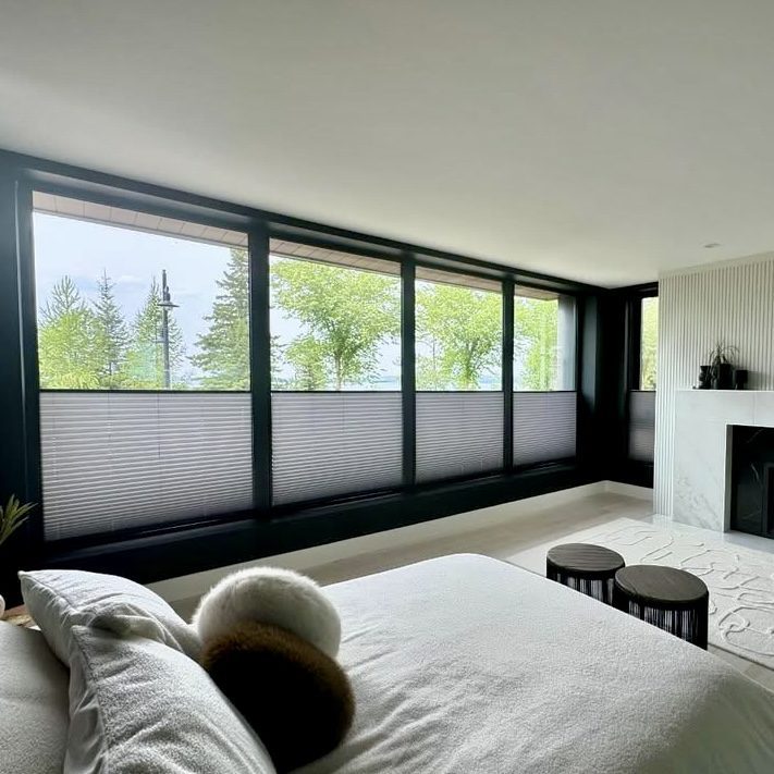 Here are a few alt text options incorporating the keyword home finds, depending on where you plan to post: Concise & Direct (Best for Web Accessibility): Modern bedroom featuring gray top-down bottom-up window blinds, a neutral bed, and a marble fireplace—a stylish home finds accent for large windows overlooking trees.