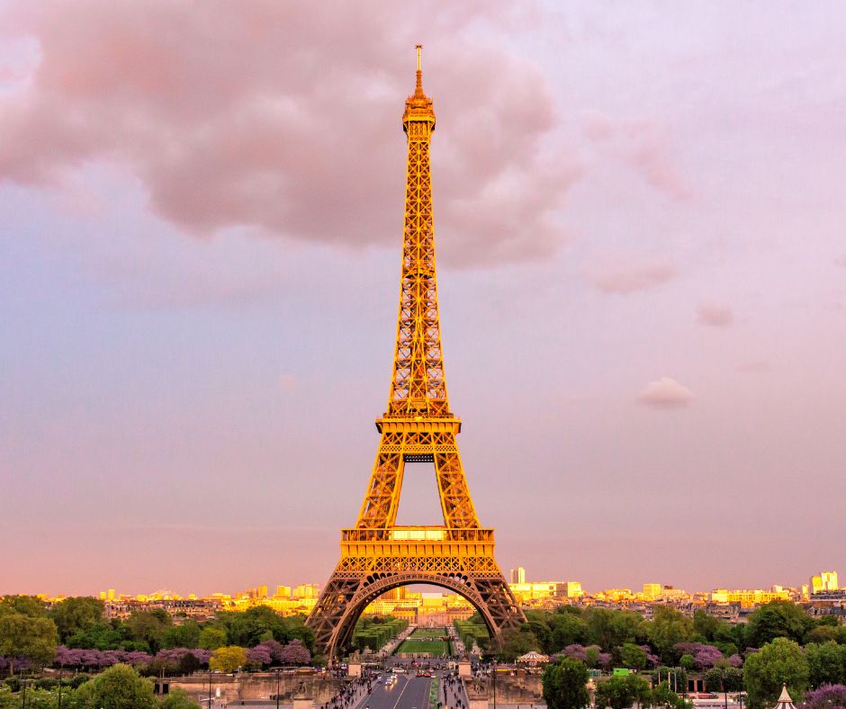Eiffel Tower in Paris standing tall against a pink sunset sky over the city view